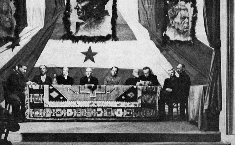 Radno predsjedništvo Trećeg zasjedanja ZAVNOH-a u Topuskom, 8.-9. svibnja 1944. U sredini Vladimir Nazor. Predsjedništvo ZAVNOH-a činili su: Vladimir Nazor (neovisan, pjesnik), Andrija Hebrang (KPH), Ivan Gošnjak (KPH), Franjo Gaži (HSS), Stjepan Prvčić (HSS), Filip Lakuš (HSS), Rade Pribićević (SDS), Simo Eror (SDS), Svetozar Rittig (katolički svećenik) i Ante Mandić (neovisan). Izvor: Javna domena.
